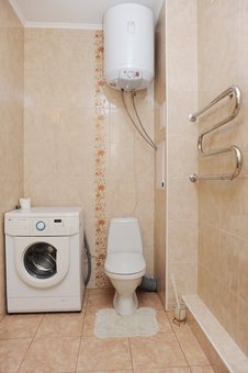 A bathroom with a washing machine in a two-room suite &quot;wellcome24&quot; in kiev on the left bank. shoot for the action.