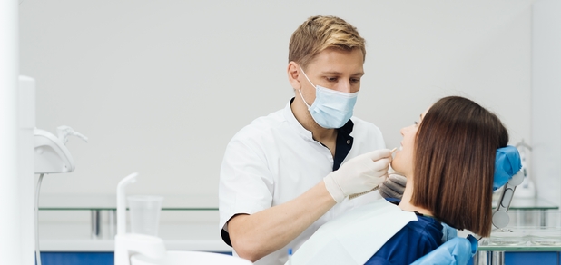 https://cdn1.pokupon.ua/uploaded/new_campaign_pictures/930519/data/main620x292/close-up-portrait-beautiful-young-lady-sitting-dental-chair-while-stomatologist-hands-sterile-gloves-holding-tooth-samples.jpg?1739794187