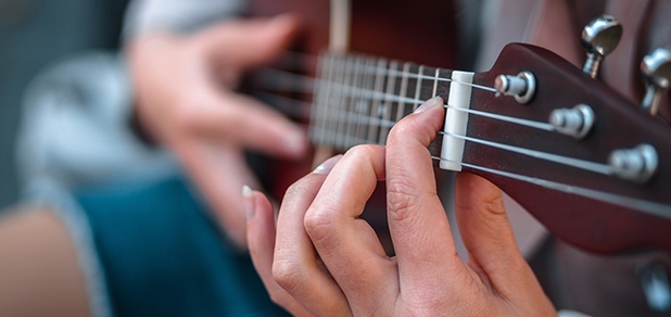 https://cdn1.pokupon.ua/uploaded/new_campaign_pictures/963462/data/main620x292/shallow-focus-shot-person-wearing-jeans-while-playing-song-ukulele.jpg?1783336786
